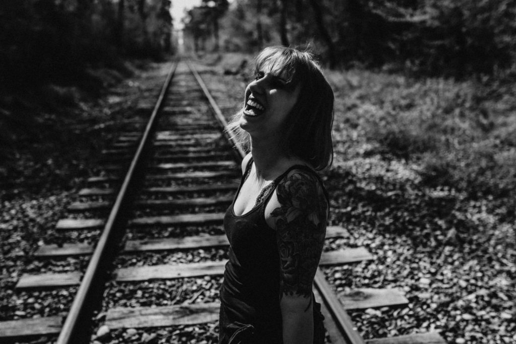 Séance photo et vidéo. Portrait de femme, boudoir, sur chemin de fer. Tatouage. Portrait en noir et blanc