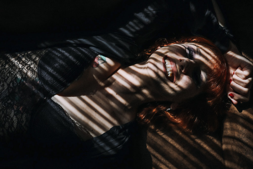 Portrait photo femme boudoir sur canapé, rayons de lumière